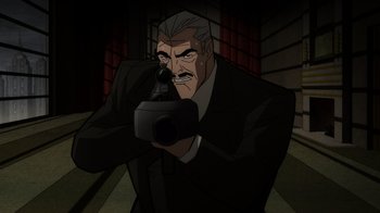 Movie still from “Batman: The Long Halloween, Part Two” (2021), directed by Chris Palmer – An older man in a suit is holding a camera; Medium shot, Low angle