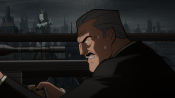 Movie still from “Batman: The Long Halloween, Part Two” (2021), directed by Chris Palmer – An animated man in a black suit is looking at a woman; Medium shot, Over the shoulder angle