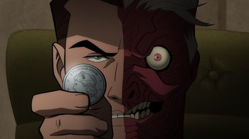 Movie still from “Batman: The Long Halloween, Part Two” (2021), directed by Chris Palmer – A man holding a coin in front of an evil face; Extreme Close Up shot, Overhead angle
