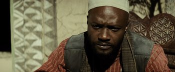 Movie still from “Batman v Superman: Dawn of Justice” (2016), directed by Zack Snyder – A person with a beard wearing a hat; Close Up shot, Low angle