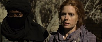 Movie still from “Batman v Superman: Dawn of Justice” (2016), directed by Zack Snyder – A person wearing a scarf near a tree; Close Up shot, Over the shoulder angle