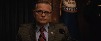 Movie still from “Batman v Superman: Dawn of Justice” (2016), directed by Zack Snyder – A person wearing a suit and tie; Close Up shot, Over the shoulder angle