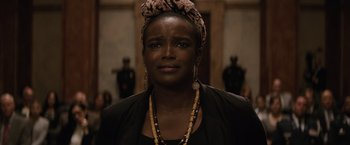 Movie still from “Batman v Superman: Dawn of Justice” (2016), directed by Zack Snyder – A woman wearing a head scarf and a necklace; Close Up shot, Over the shoulder angle