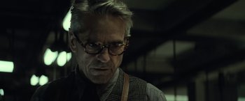 Movie still from “Batman v Superman: Dawn of Justice” (2016), directed by Zack Snyder – An older man wearing glasses and wearing a tie; Close Up shot, Low angle