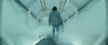 Movie still from “Batman v Superman: Dawn of Justice” (2016), directed by Zack Snyder – A man is walking down the escalator with a briefcase; Wide shot, Low angle