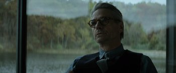 Movie still from “Batman v Superman: Dawn of Justice” (2016), directed by Zack Snyder – An older man wearing glasses and a bow tie; Close Up shot, Over the shoulder angle