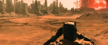Movie still from “Batman v Superman: Dawn of Justice” (2016), directed by Zack Snyder – A man riding a motorcycle on top of a dirt field; Extreme Wide shot, High angle