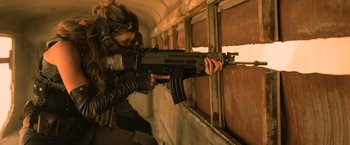 Movie still from “Batman v Superman: Dawn of Justice” (2016), directed by Zack Snyder – A woman holding a gun while standing next to a window; Medium shot, Over the shoulder angle