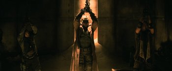 Movie still from “Batman v Superman: Dawn of Justice” (2016), directed by Zack Snyder – A man in a trench coat holding a chain; Wide shot, Low angle