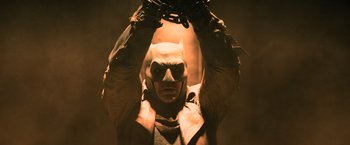 Movie still from “Batman v Superman: Dawn of Justice” (2016), directed by Zack Snyder – A man wearing a batman mask and holding a chain; Medium shot, Low angle