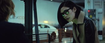 Movie still from “Batman v Superman: Dawn of Justice” (2016), directed by Zack Snyder – A woman wearing sunglasses and a black hat; Close Up shot, Over the shoulder angle