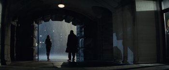 Movie still from “Batman v Superman: Dawn of Justice” (2016), directed by Zack Snyder – A person standing in the rain under a bridge; Wide shot, Low angle