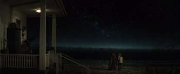Movie still from “Batman v Superman: Dawn of Justice” (2016), directed by Zack Snyder – A person standing on a beach under a night sky; Extreme Wide shot, Low angle