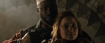 Movie still from “Batman v Superman: Dawn of Justice” (2016), directed by Zack Snyder – A man and a woman holding a gun in a dark room; Close Up shot, Low angle