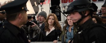 Movie still from “Batman v Superman: Dawn of Justice” (2016), directed by Zack Snyder – A group of people standing next to each other on a street; Medium shot, Over the shoulder angle