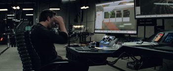 Movie still from “Batman v Superman: Dawn of Justice” (2016), directed by Zack Snyder – A man sitting in front of a computer monitor; Medium shot, Over the shoulder angle