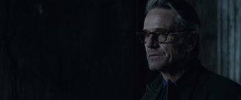 Movie still from “Batman v Superman: Dawn of Justice” (2016), directed by Zack Snyder – An older man wearing glasses looking at the camera; Close Up shot, Over the shoulder angle