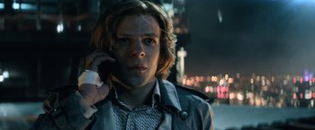 Movie still from “Batman v Superman: Dawn of Justice” (2016), directed by Zack Snyder – A young man is talking on a cell phone while standing in the street; Close Up shot, Low angle
