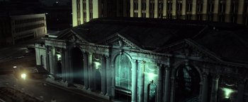 Movie still from “Batman v Superman: Dawn of Justice” (2016), directed by Zack Snyder – An old building with pillars and a bird cage on top of it at night; Extreme Wide shot, High angle
