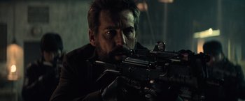 Movie still from “Batman v Superman: Dawn of Justice” (2016), directed by Zack Snyder – A person holding a gun; Close Up shot, Over the shoulder angle