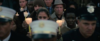 Movie still from “Batman v Superman: Dawn of Justice” (2016), directed by Zack Snyder – A group of people holding lit candles in a crowd; Close Up shot, Over the shoulder angle