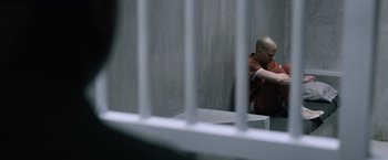 Movie still from “Batman v Superman: Dawn of Justice” (2016), directed by Zack Snyder – A man in a jail cell hugging another man; Wide shot, High angle