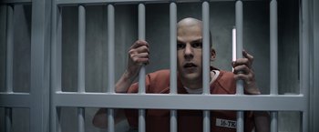 Movie still from “Batman v Superman: Dawn of Justice” (2016), directed by Zack Snyder – A man in a jail cell with his hands on the bars; Close Up shot, Low angle