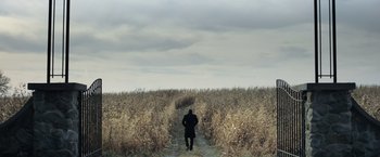 Movie still from “Batman v Superman: Dawn of Justice” (2016), directed by Zack Snyder – A man standing on a dirt path in a field; Extreme Wide shot, High angle