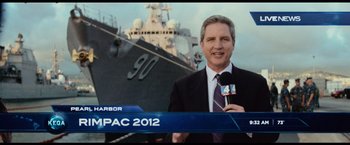 Movie still from “Battleship” (2012), directed by Peter Berg – A man standing in front of a large ship; Medium shot, Over the shoulder angle