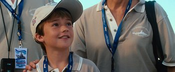 Movie still from “Battleship” (2012), directed by Peter Berg – A boy and a woman wearing a hat and a lanyard; Close Up shot, High angle
