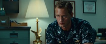 Movie still from “Battleship” (2012), directed by Peter Berg – A person sitting in front of a lamp; Close Up shot, Over the shoulder angle