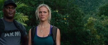 Movie still from “Battleship” (2012), directed by Peter Berg – A woman with a backpack standing in front of a tree; Close Up shot, Over the shoulder angle