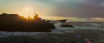 Movie still from “Battleship” (2012), directed by Peter Berg – A large boat is in the water near the shore; Extreme Wide shot, High angle