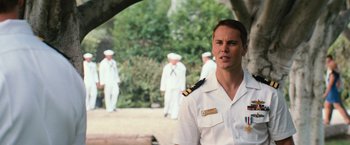Movie still from “Battleship” (2012), directed by Peter Berg – A man in a uniform standing in front of a group of people; Medium shot, Over the shoulder angle