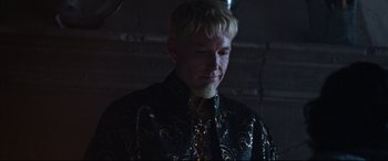 Movie still from “The Last Duel” (2021), directed by Ridley Scott – A man with blonde hair wearing a black and gold jacket; Close Up shot, Over the shoulder angle