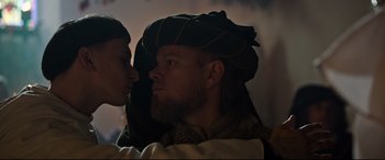 Movie still from “The Last Duel” (2021), directed by Ridley Scott – A man with a long beard wearing a hat; Close Up shot, Over the shoulder angle