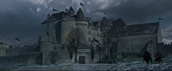 Movie still from “The Last Duel” (2021), directed by Ridley Scott – An old castle with a dark sky in the background; Extreme Wide shot, High angle