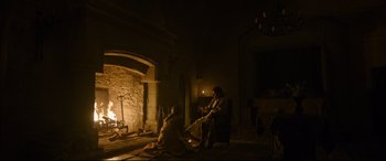 Movie still from “The Last Duel” (2021), directed by Ridley Scott – Two people sitting in front of a fire place; Wide shot, High angle