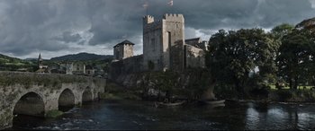 Movie still from “The Last Duel” (2021), directed by Ridley Scott – A castle with a boat in the water; Extreme Wide shot, Low angle