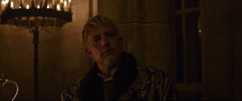 Movie still from “The Last Duel” (2021), directed by Ridley Scott – A man with a white beard wearing a black and gold jacket; Close Up shot, Over the shoulder angle