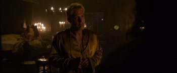 Movie still from “The Last Duel” (2021), directed by Ridley Scott – A man standing in the dark wearing a robe; Medium shot, Over the shoulder angle