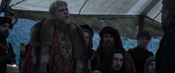 Movie still from “The Last Duel” (2021), directed by Ridley Scott – A group of men standing next to each other under an awning; Medium shot, Low angle