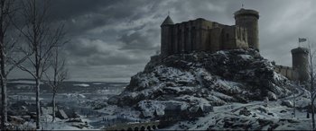 Movie still from “The Last Duel” (2021), directed by Ridley Scott – A castle on top of a hill with snow on the ground; Extreme Wide shot, Low angle