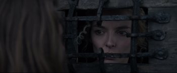 Movie still from “The Last Duel” (2021), directed by Ridley Scott – A woman looking through the bars of a jail cell; Close Up shot, Over the shoulder angle