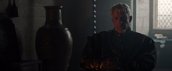 Movie still from “The Last Duel” (2021), directed by Ridley Scott – A man sitting in front of a vase in a dark room; Close Up shot, Over the shoulder angle