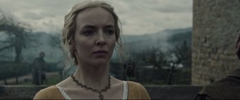 Movie still from “The Last Duel” (2021), directed by Ridley Scott – A woman in a yellow shirt is looking at the camera; Close Up shot, Low angle