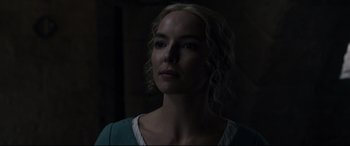 Movie still from “The Last Duel” (2021), directed by Ridley Scott – A woman with blonde curly hair is looking at the camera; Close Up shot, Over the shoulder angle