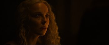 Movie still from “The Last Duel” (2021), directed by Ridley Scott – A woman with long blonde curly hair stares into the camera; Close Up shot, Over the shoulder angle