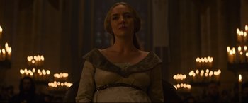 Movie still from “The Last Duel” (2021), directed by Ridley Scott – A woman in a white dress is standing in front of a window; Medium shot, Low angle