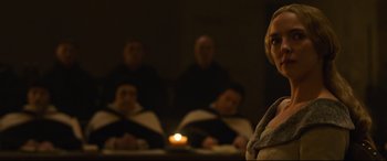 Movie still from “The Last Duel” (2021), directed by Ridley Scott – A group of people sitting in a room with a candle; Close Up shot, Over the shoulder angle